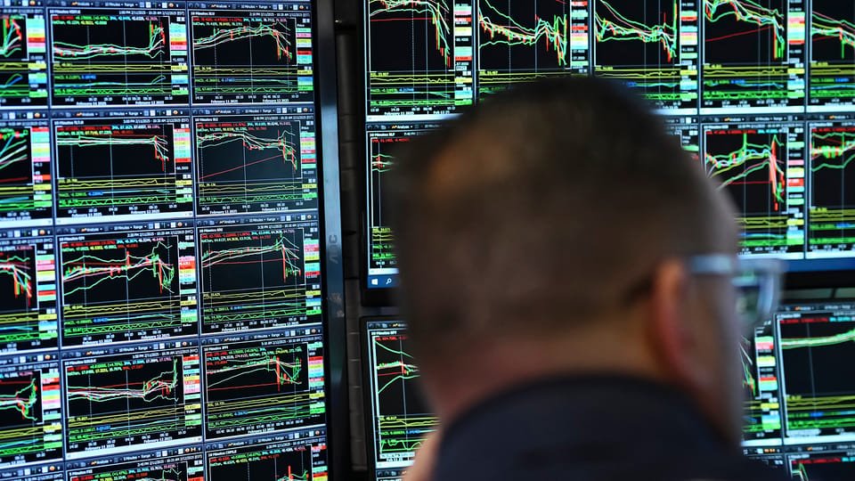 Trading screens show stock market charts.