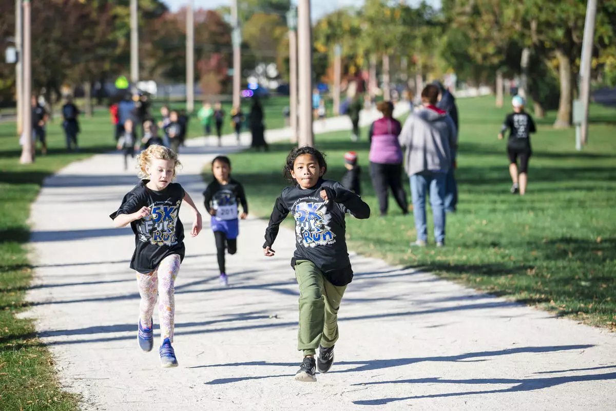 Runners at a charity fun run in a park.