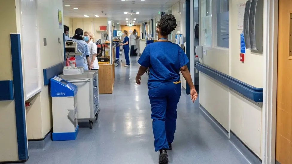 A nurse walking a hospital corridor.