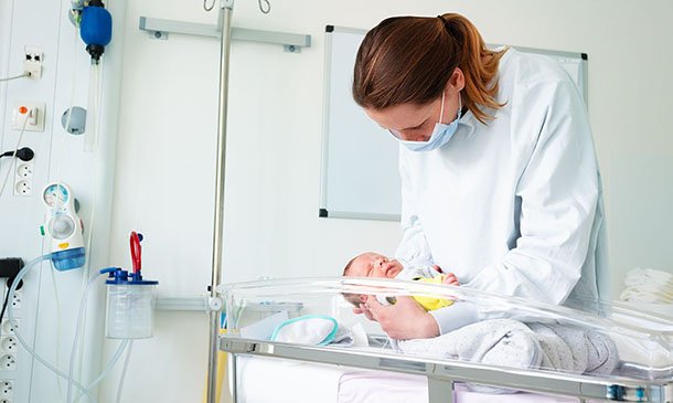 A nurse cares for a newborn in a hospital unit. A new white paper backs a bigger role for perinatal specialists.