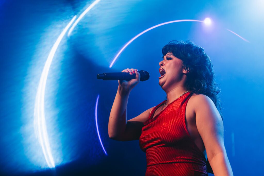Lola Young performing live on stage.