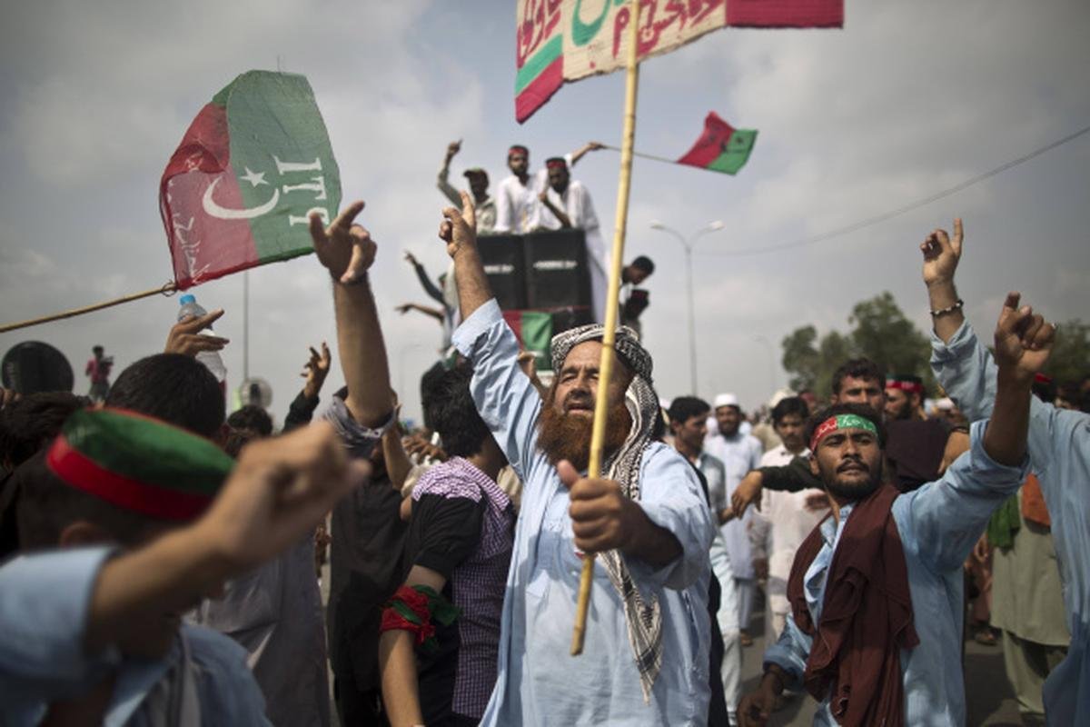 Supporters of former Pakistani Prime Minister Imran Khan march in a vehicle convoy toward Islamabad to demand his release.
