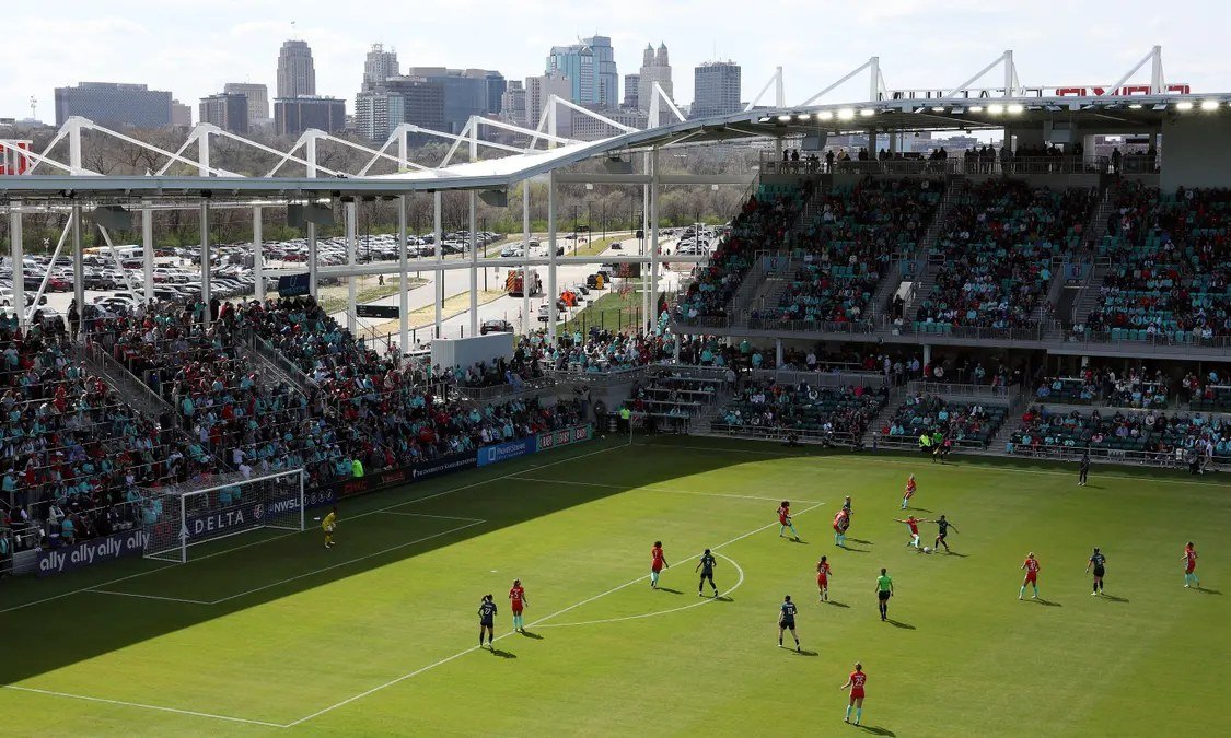 A women's soccer match under stadium lights.